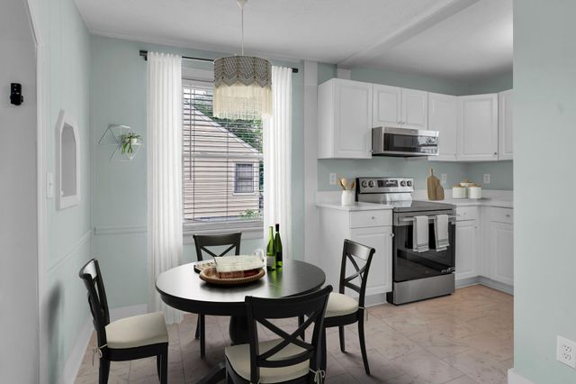 a kitchen with stainless steel appliances a table chairs and a refrigerator