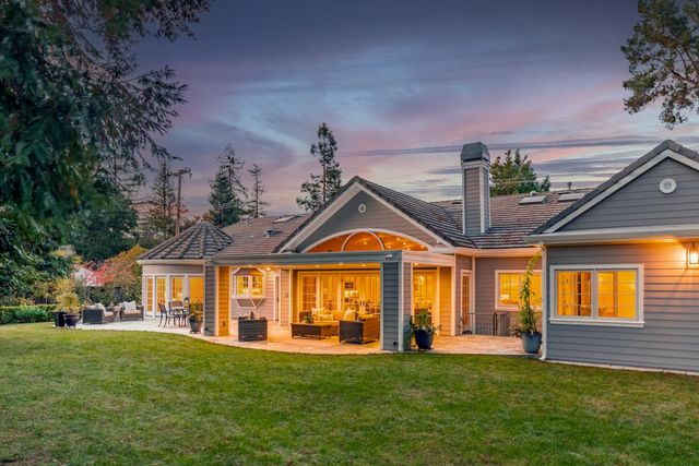 a front view of a house with a big yard and potted plants