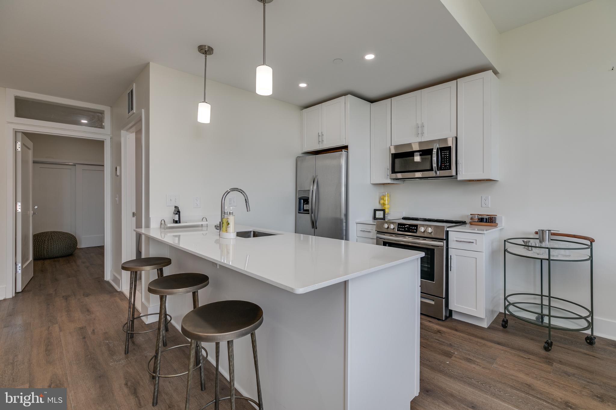 150 South Independence Mall West, Unit 403 Philadelphia, PA 19106 - Photo 12 of 19 a kitchen with stainless steel appliances a stove a sink and a refrigerator with wooden floor