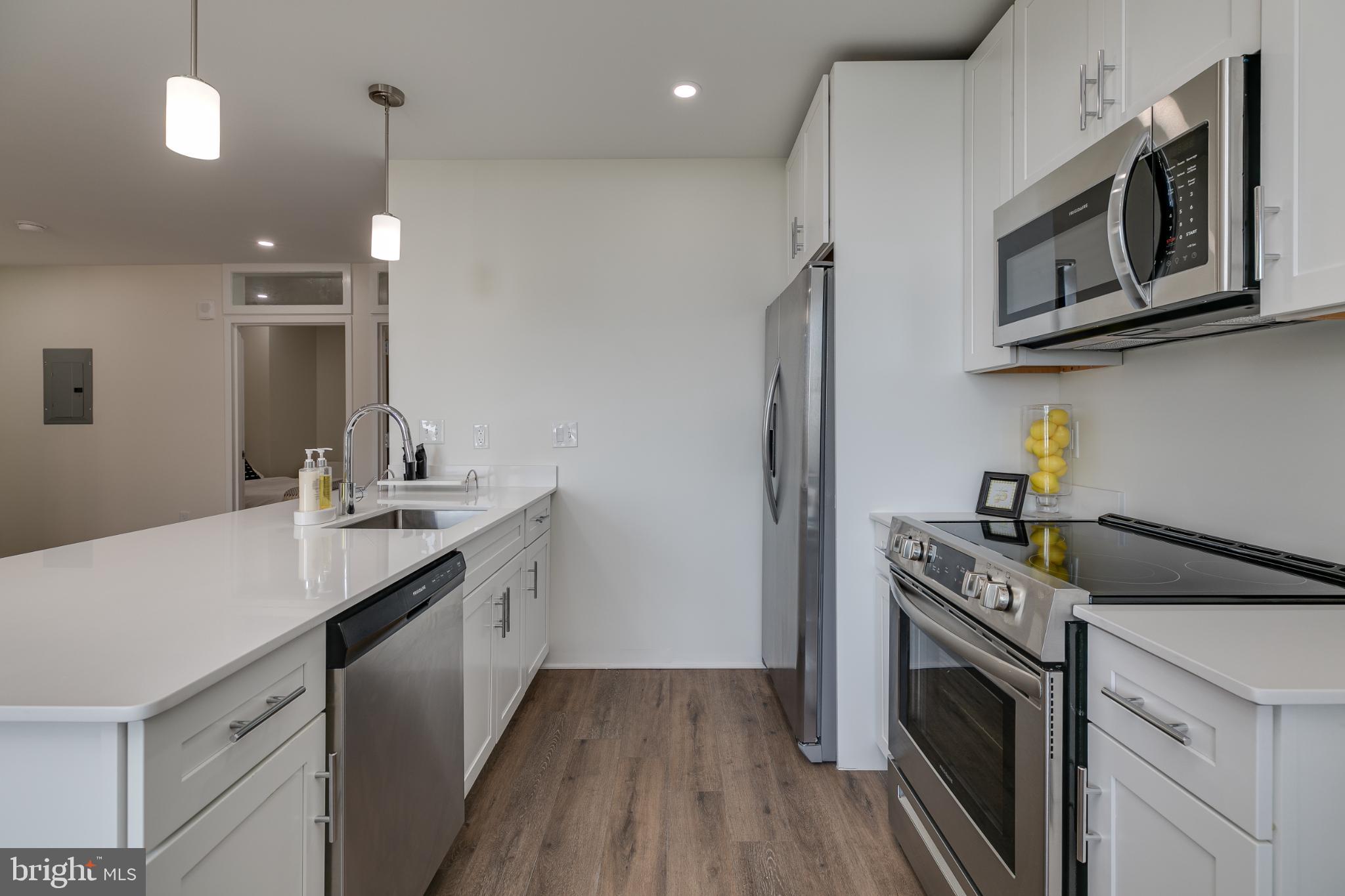 150 South Independence Mall West, Unit 403 Philadelphia, PA 19106 - Photo 14 of 19 a kitchen with stainless steel appliances granite countertop a sink a stove a refrigerator and a microwave