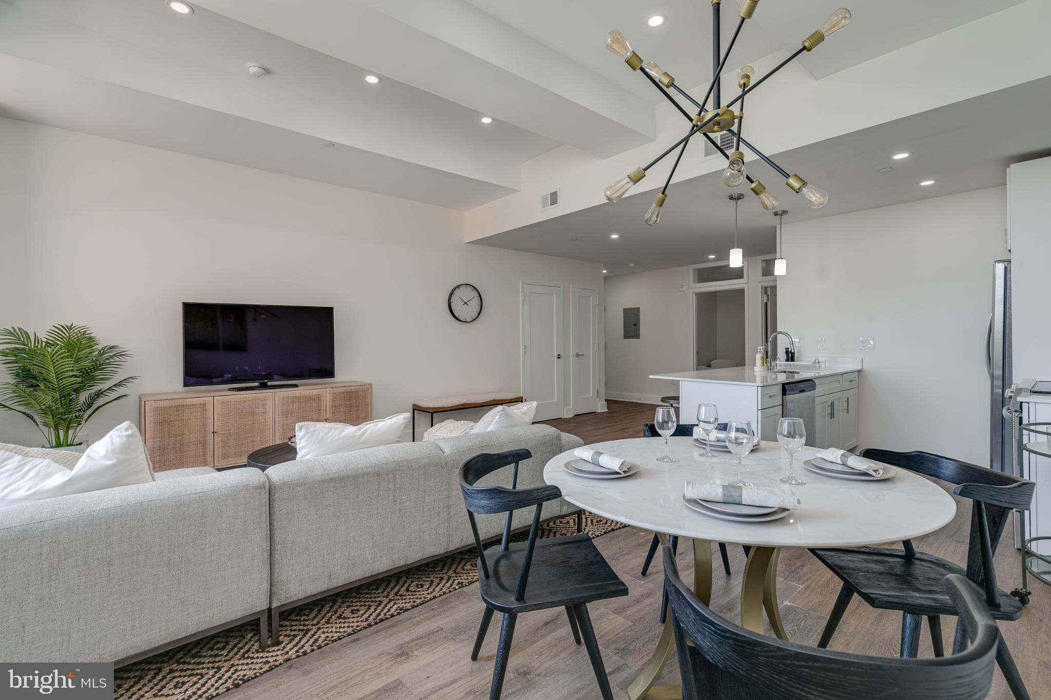 150 South Independence Mall West, Unit 403 Philadelphia, PA 19106 - Photo 17 of 19 a living room with furniture a chandelier and a flat screen tv