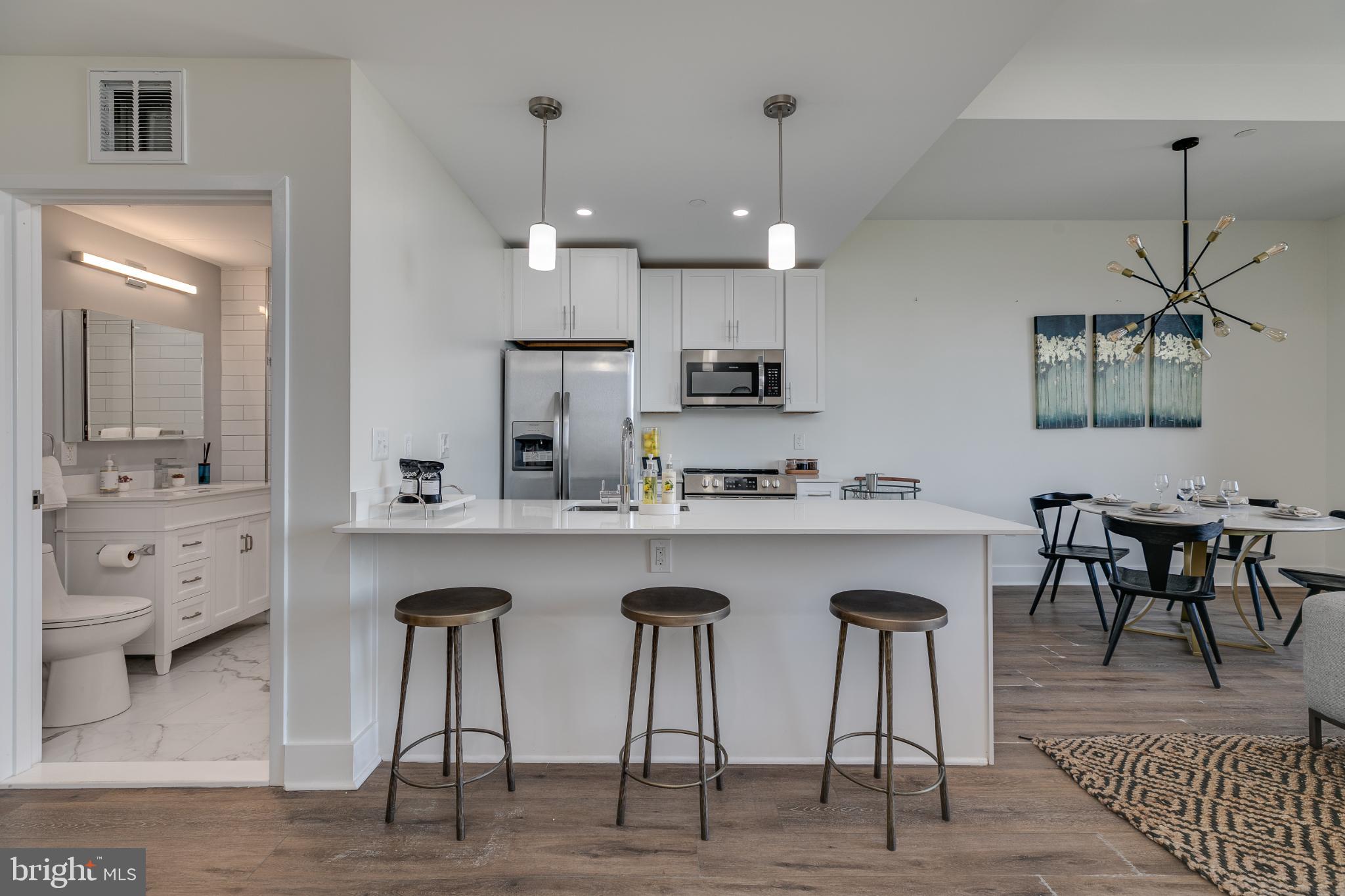 150 South Independence Mall West, Unit 403 Philadelphia, PA 19106 - Photo 19 of 19 a kitchen with stainless steel appliances a table chairs refrigerator and cabinets