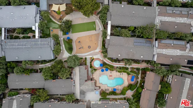 an aerial view of residential houses with outdoor space and parking