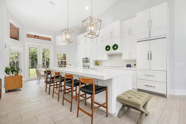 a dining room with wooden floor a chandelier a wooden table and chairs