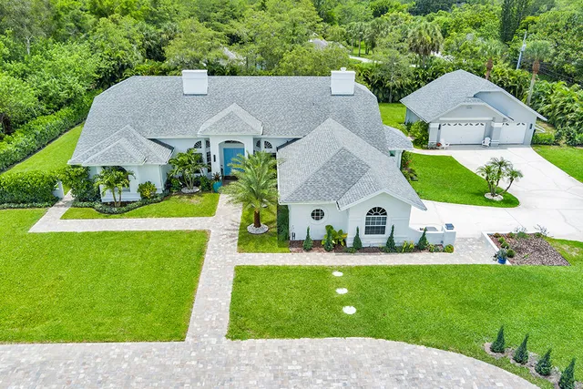 a aerial view of a house with a yard table and chairs