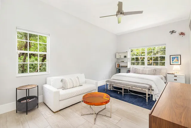 a spacious bedroom with a bed a couch and a window