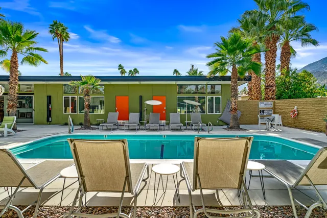 a view of an house with swimming pool and sitting area