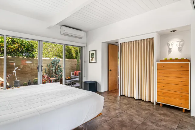 a bedroom with a bed and large mirror