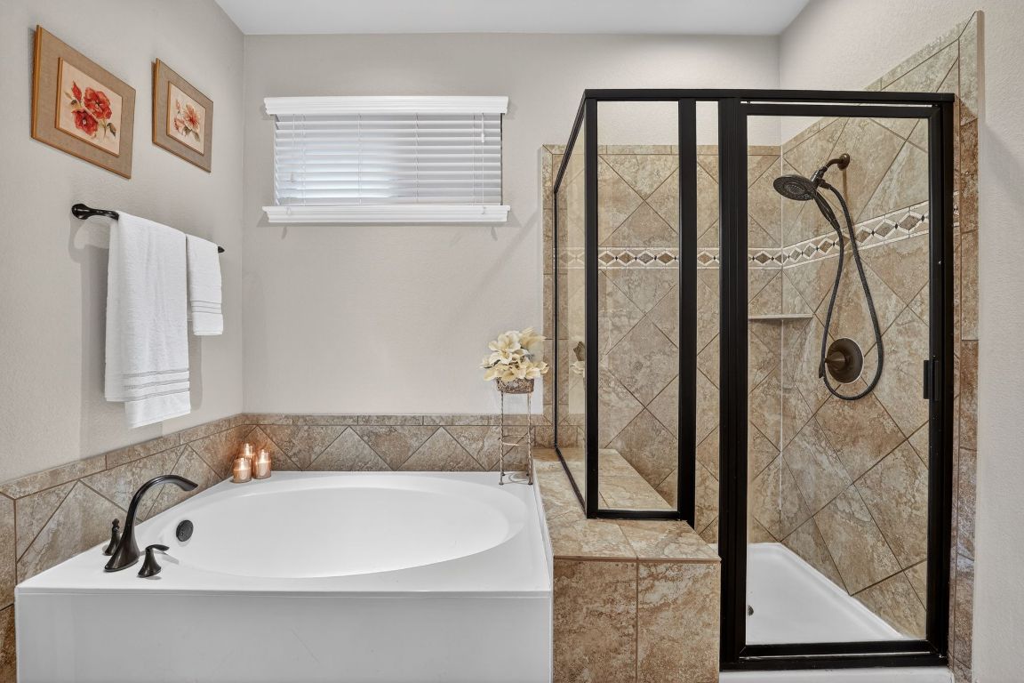 4521 Pyrenees Pass Bee Cave, TX 78738 - Photo 14 of 22 a bathroom with a tub and a shower
