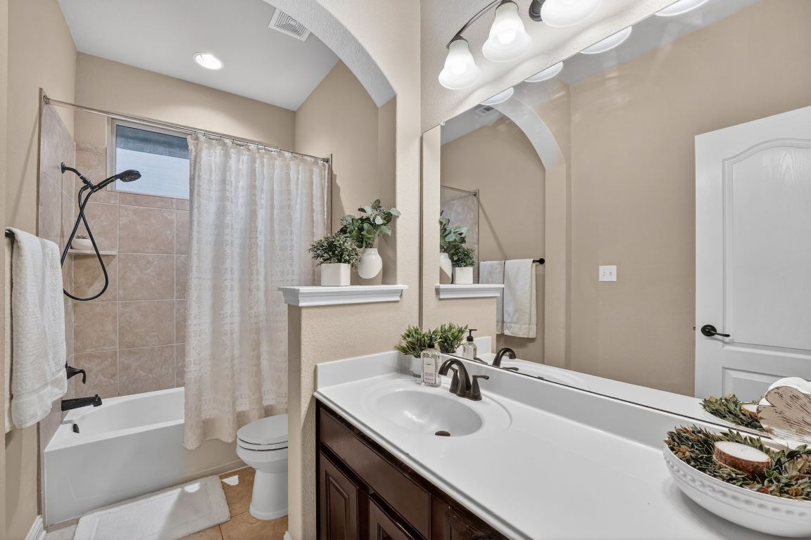 4521 Pyrenees Pass Bee Cave, TX 78738 - Photo 17 of 22 a bathroom with a sink vanity mirror and toilet
