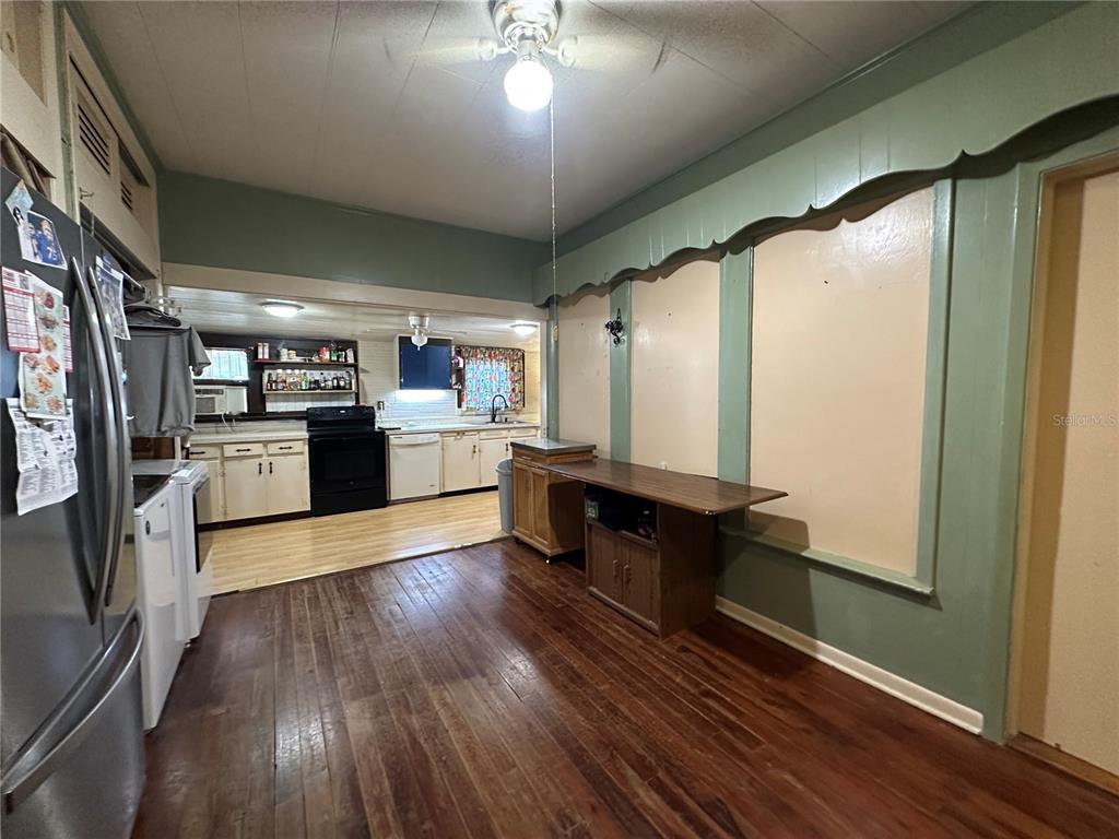 513 West Main Street Wauchula, FL 33873 - Photo 27 of 43 a kitchen with stainless steel appliances granite countertop a refrigerator a stove and a wooden floors