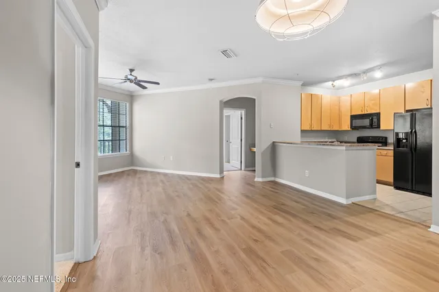 a view of a kitchen with a sink cabinet a refrigerator and windows