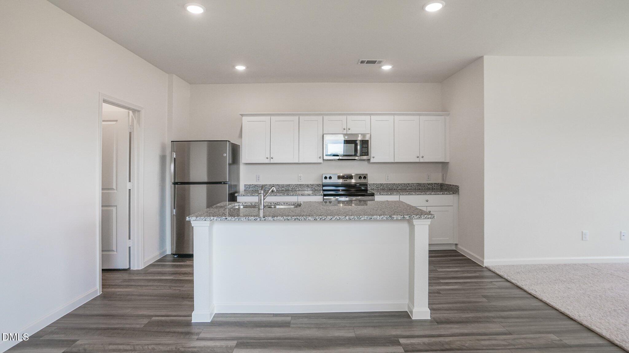 1304 Solace Way Rolesville, NC 27571 - Photo 14 of 34 a kitchen with stainless steel appliances a sink stove and refrigerator