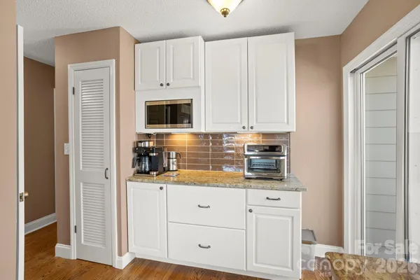 a kitchen with granite countertop white cabinets and stainless steel appliances