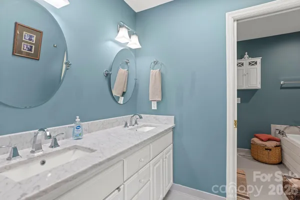 a en suite bathroom with a double vanity sink and a mirror