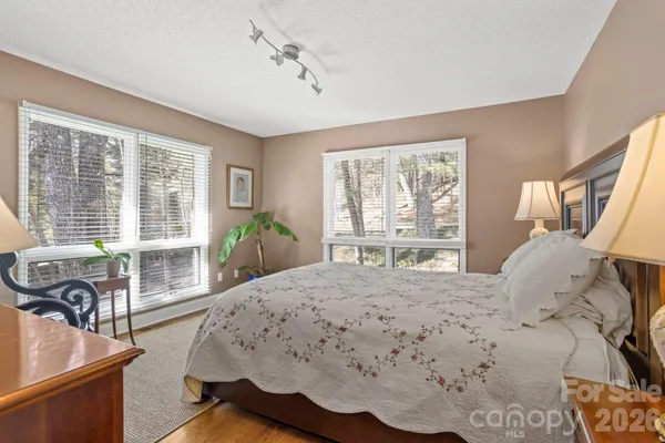 a bedroom with a large bed and wooden floor