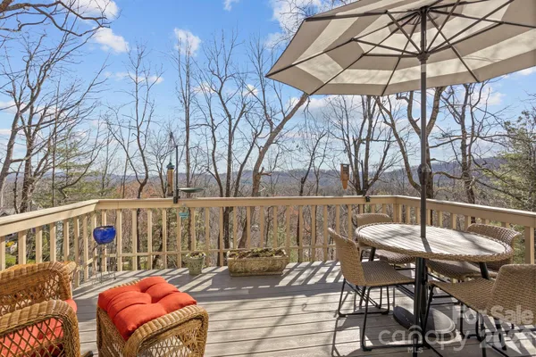 a backyard of a house with table and chairs under an umbrella