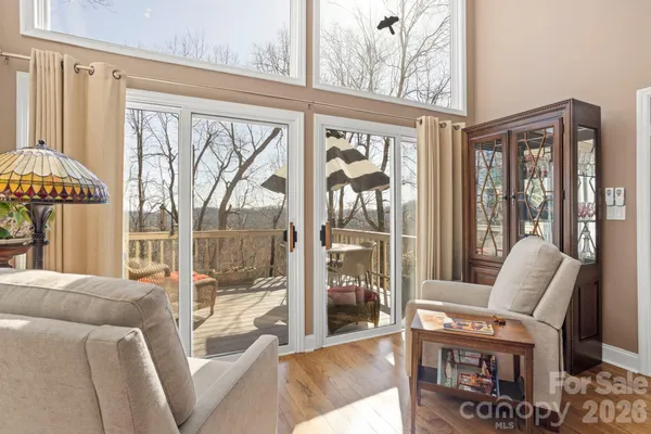 a living room with furniture a flat screen tv and a floor to ceiling window