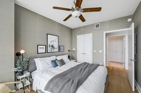 a bedroom with a large bed and a ceiling fan