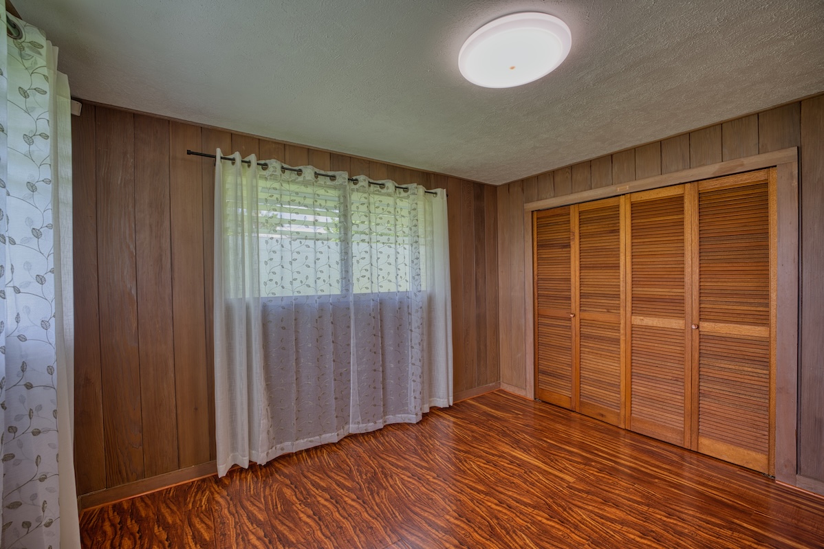 27-296 Ka'ie'ie Road Papaikou, HI 96781 - Photo 22 of 28 an empty room with wooden floor and windows