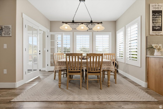 3123 East Riverdale Road Preston, ID 83263 - Photo 15 of 52 Dining area featuring wood-finish flooring, white plantation shutters, a multi-light pendant fixture, and French doors
