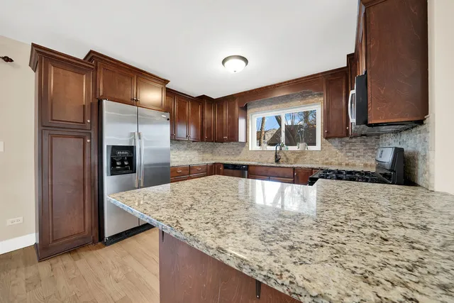 a kitchen with stainless steel appliances granite countertop a sink refrigerator and microwave