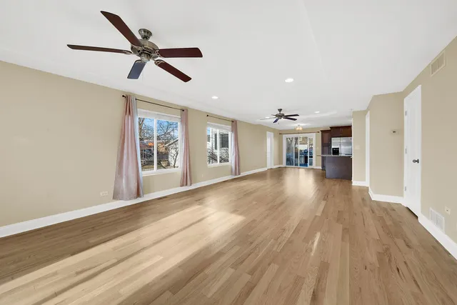 a view of empty room with wooden floor and window