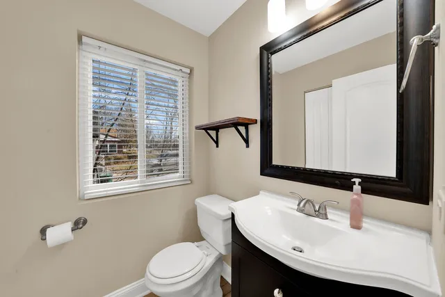 a bathroom with a sink vanity mirror and toilet