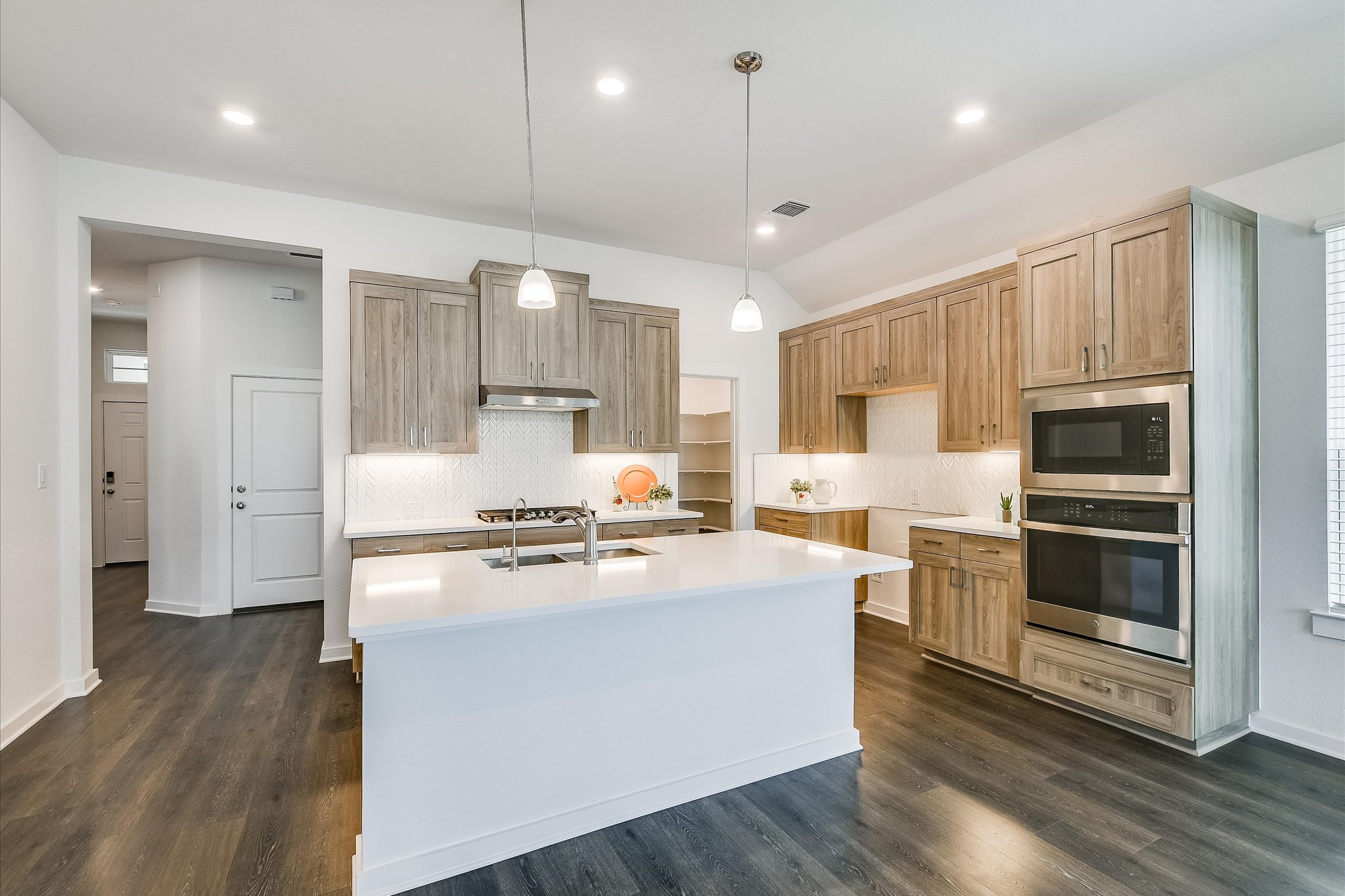205 Wingstem Way Georgetown, TX 78633 - Photo 5 of 29 Kitchen featuring a central island with an integrated sink, pendant lighting, and soft-close cabinetry.