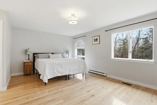 a bedroom with a bed and wooden floor