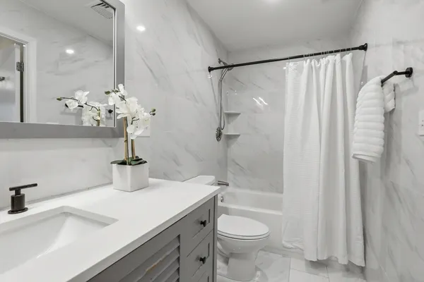 a bathroom with a sink a toilet and a mirror