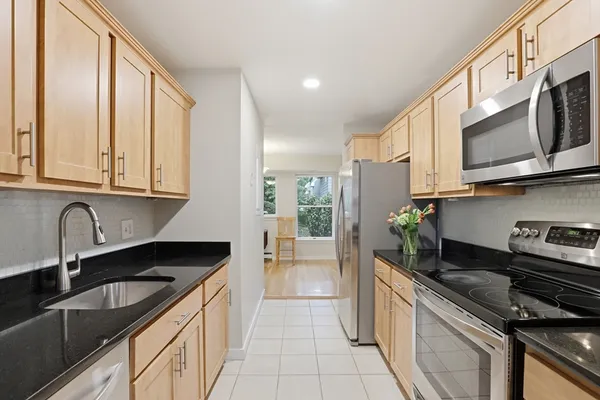 a kitchen with stainless steel appliances granite countertop a sink stove and cabinets