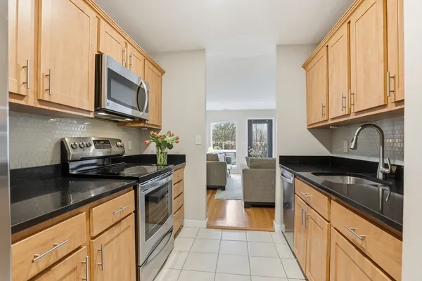 a kitchen with granite countertop a sink stainless steel appliances a counter space and cabinets