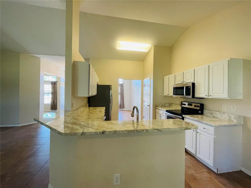 117 Angol Street Punta Gorda, FL 33983 - Photo 5 of 20 a kitchen with stainless steel appliances granite countertop a sink a stove top oven a counter space and cabinets