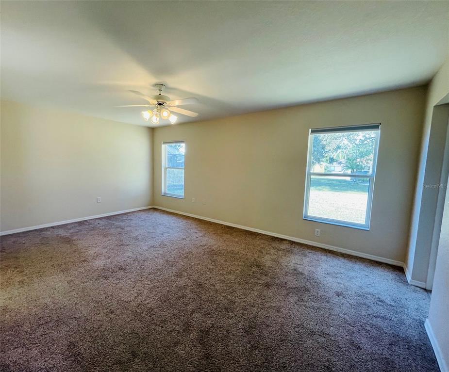 117 Angol Street Punta Gorda, FL 33983 - Photo 9 of 20 an empty room with windows and ceiling fan