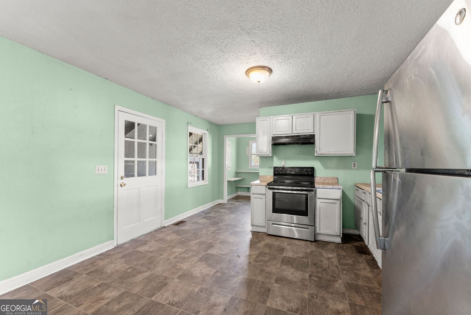 2346 4th Street Gainesville, GA 30504 - Photo 6 of 36 a kitchen with granite countertop a refrigerator and a stove