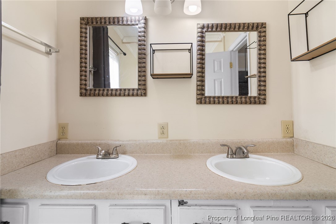 2924 Walden Road Fayetteville, NC 28303 - Photo 26 of 44 a bathroom with double vanity sinks and a mirror