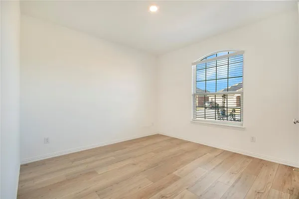 a view of a room that has wooden floor and a window