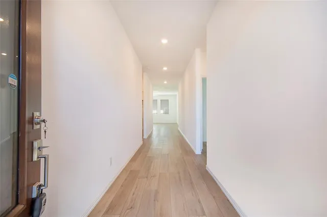 a view of a hallway with wooden floor