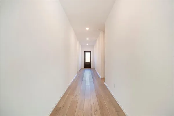 a view of a hallway with wooden floor and staircase