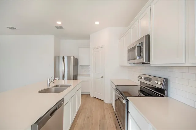a kitchen with a sink a stove and cabinets
