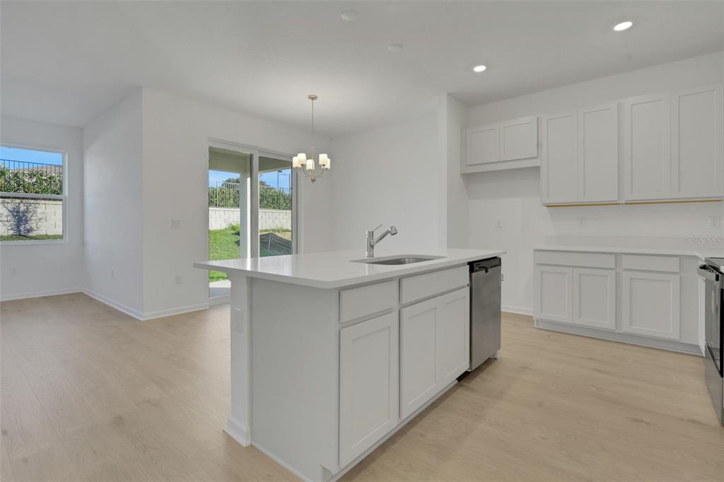 2824 Doolittle Street Tavares, FL 32778 - Photo 21 of 32 a kitchen with white cabinets and window