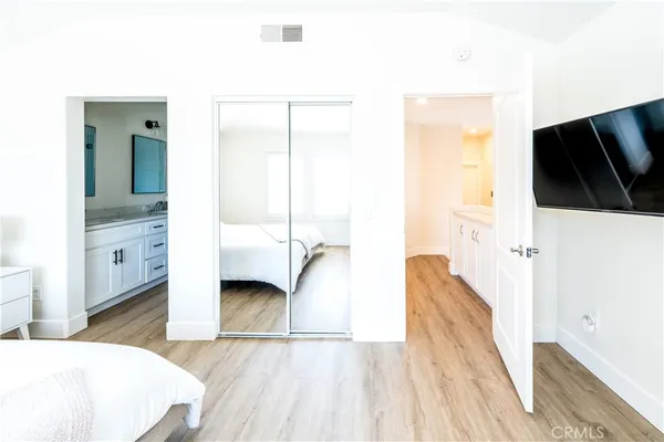 a bedroom with a bed and a flat tv screen on dresser