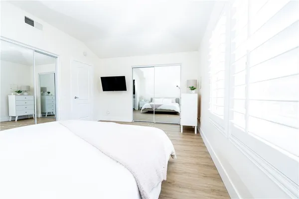 a bedroom with a bed and wooden floor