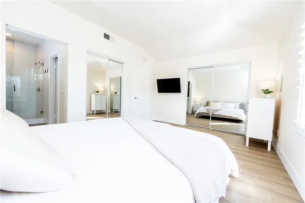 a bedroom with a bed and a flat screen tv