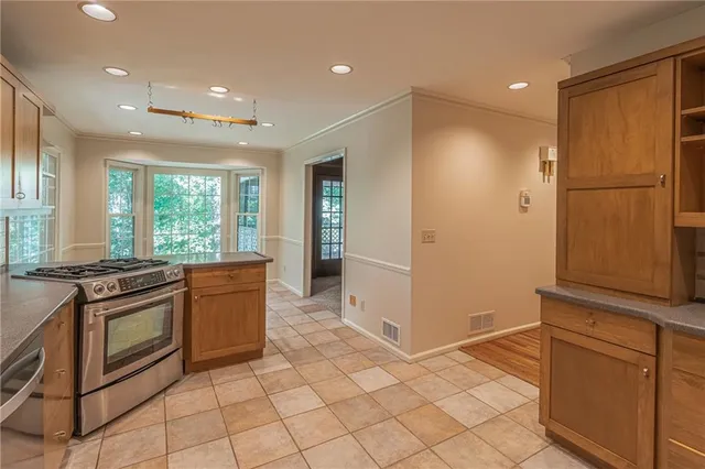 a kitchen with stainless steel appliances granite countertop a refrigerator and a stove top oven
