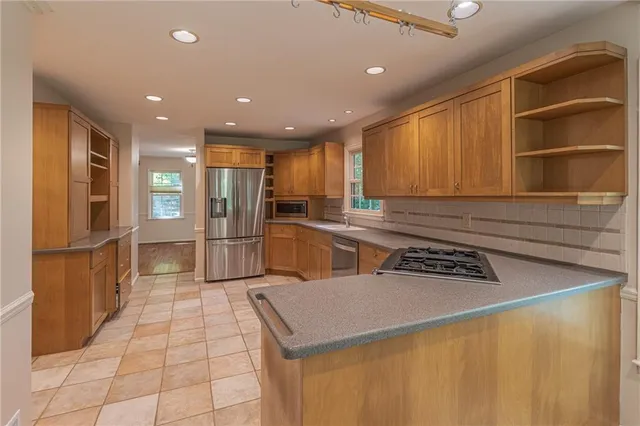 a kitchen with stainless steel appliances granite countertop a sink refrigerator and cabinets