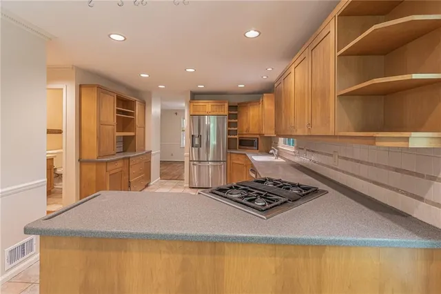 a kitchen with stainless steel appliances granite countertop a sink stove and refrigerator