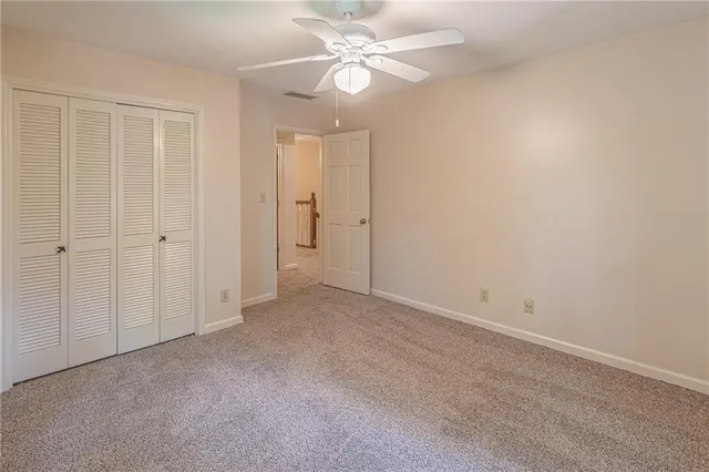 an empty room with chandelier fan