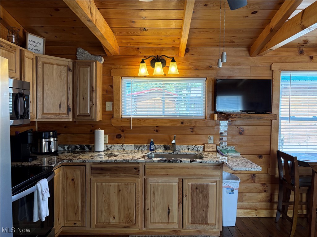 5919 Lake Road West, Unit 18 Ashtabula, OH 44004 - Photo 7 of 32 Kitchen with wooden walls, electric range, stainless steel microwave, light stone counters, and dark wood-style flooring